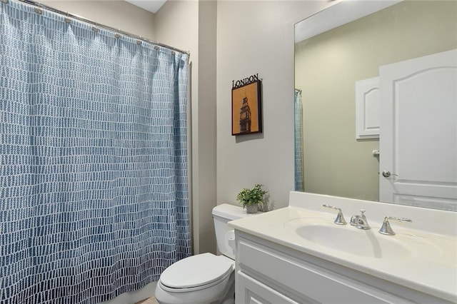 bathroom with curtained shower, vanity, and toilet