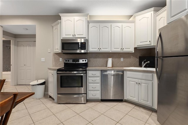 kitchen with appliances with stainless steel finishes, light countertops, and light tile patterned floors