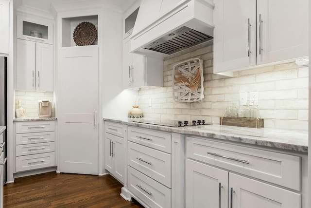 kitchen featuring premium range hood, light stone counters, black electric cooktop, dark hardwood / wood-style flooring, and white cabinets