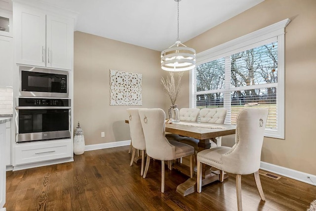 dining room featuring an inviting chandelier and dark hardwood / wood-style floors