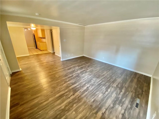 empty room with crown molding and dark hardwood / wood-style floors