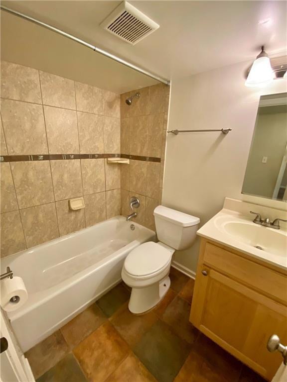 full bathroom featuring tiled shower / bath combo, vanity, and toilet