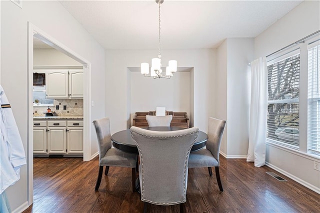 dining space featuring dark hardwood / wood-style floors and a chandelier