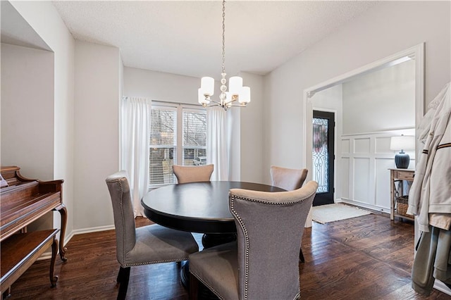 dining room with dark wood-type flooring and a chandelier