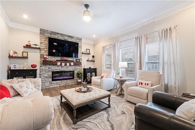 living room with hardwood / wood-style flooring, a fireplace, ornamental molding, and a textured ceiling