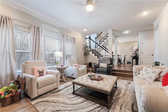 living room featuring crown molding, hardwood / wood-style flooring, and a textured ceiling