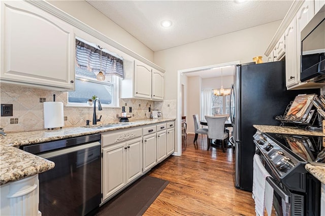 kitchen with range with electric stovetop, black dishwasher, sink, and white cabinets