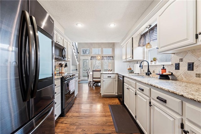 kitchen with sink, white cabinetry, tasteful backsplash, black appliances, and dark hardwood / wood-style flooring