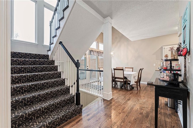 staircase featuring hardwood / wood-style floors and a textured ceiling