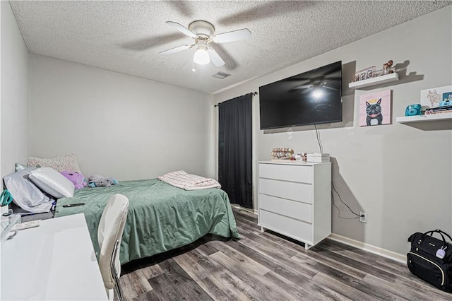 bedroom featuring ceiling fan, wood-type flooring, and a textured ceiling