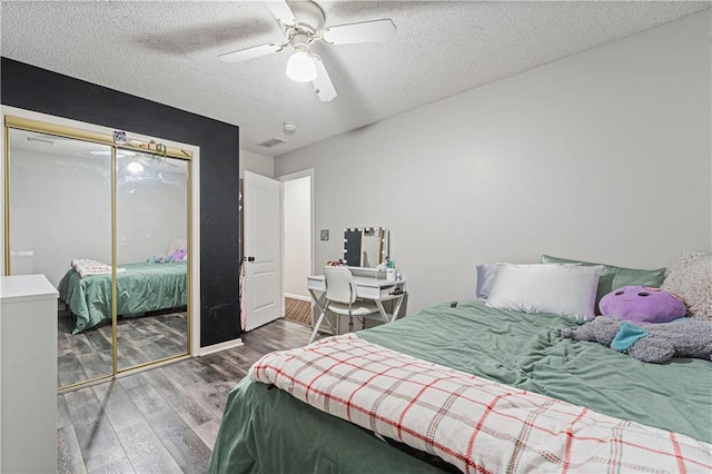 bedroom featuring wood-type flooring, ceiling fan, a textured ceiling, and a closet