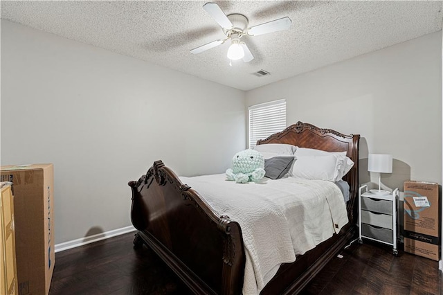 bedroom with ceiling fan, dark hardwood / wood-style floors, and a textured ceiling