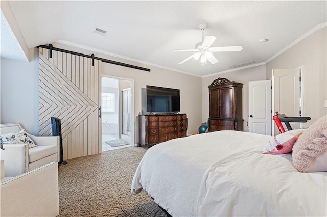 carpeted bedroom featuring ornamental molding, a barn door, connected bathroom, and ceiling fan