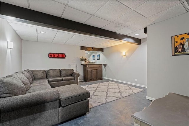 living room featuring a drop ceiling, concrete floors, and bar