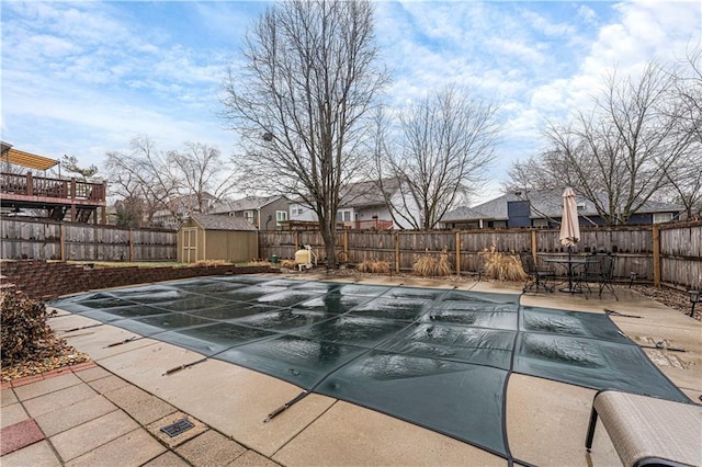 view of swimming pool featuring a patio area and a shed