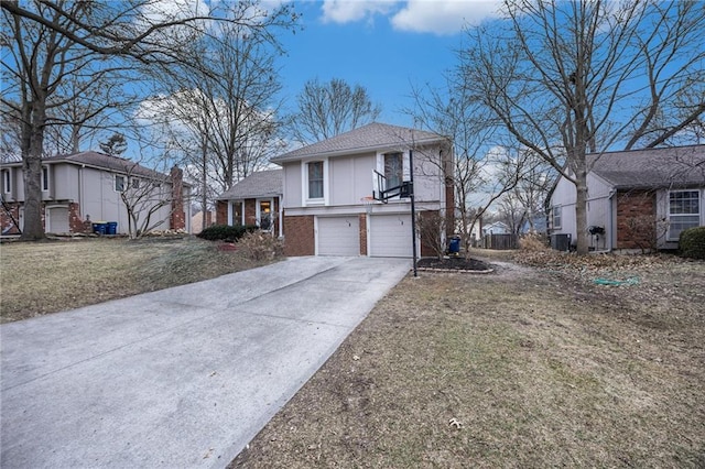 split level home featuring a garage, a front yard, and central air condition unit