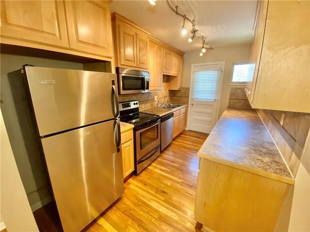 kitchen with appliances with stainless steel finishes, sink, and light brown cabinets