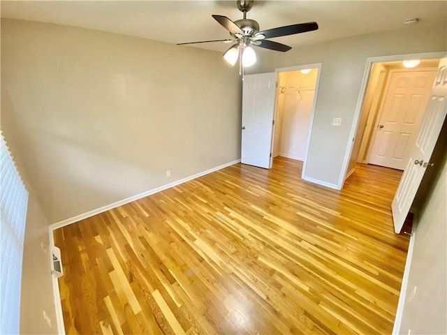 unfurnished bedroom featuring ceiling fan, light hardwood / wood-style floors, and a closet