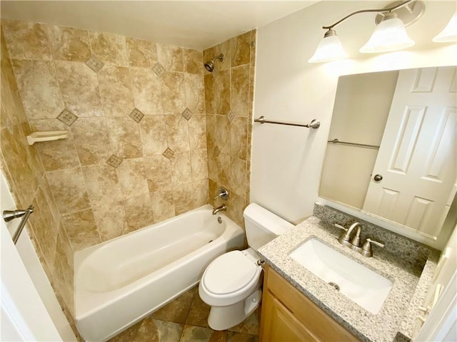 full bathroom featuring vanity, tiled shower / bath combo, and toilet