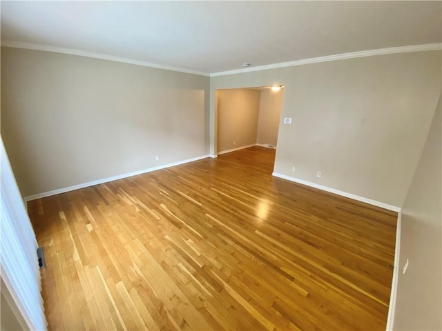 empty room featuring hardwood / wood-style flooring and ornamental molding