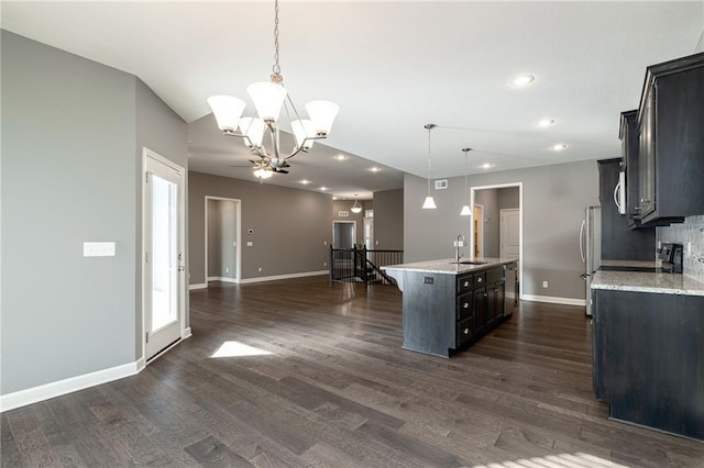 kitchen featuring a center island with sink, a chandelier, sink, pendant lighting, and dark hardwood / wood-style floors