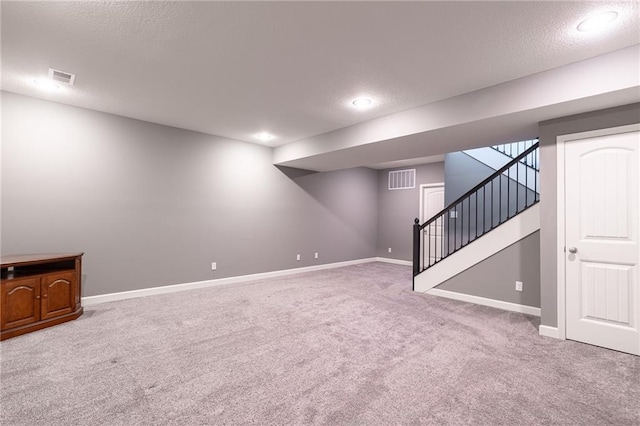 basement featuring carpet floors and a textured ceiling