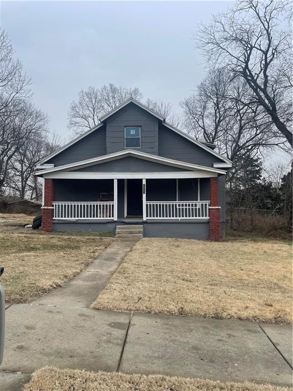 view of front of home featuring covered porch and a front lawn