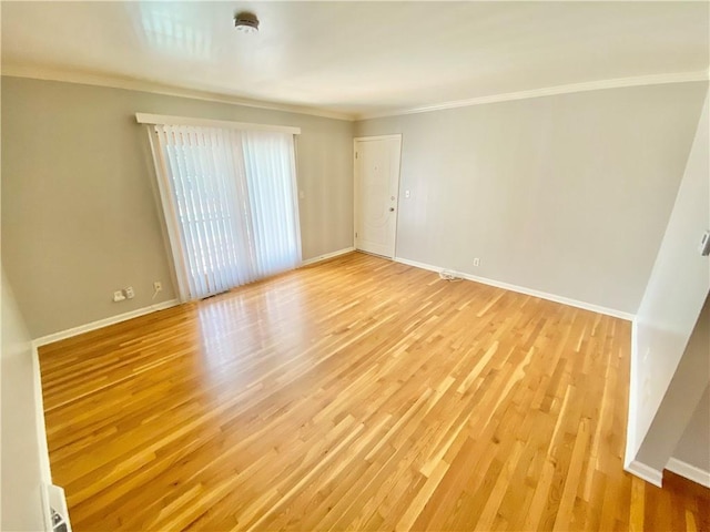 spare room featuring crown molding and light hardwood / wood-style flooring