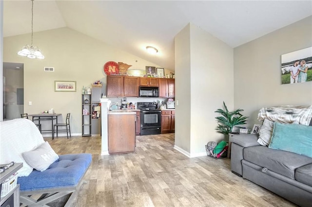 living room featuring vaulted ceiling, sink, a notable chandelier, and light hardwood / wood-style flooring