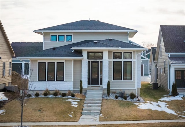 view of front of property with a front yard and central air condition unit