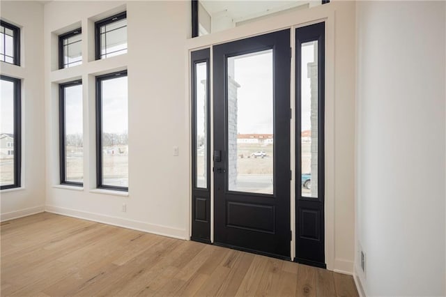 foyer with a towering ceiling and light hardwood / wood-style floors