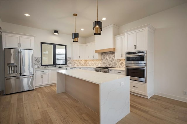 kitchen with pendant lighting, white cabinets, and appliances with stainless steel finishes