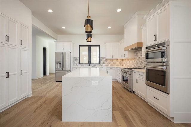 kitchen featuring white cabinetry, a center island, premium appliances, pendant lighting, and backsplash