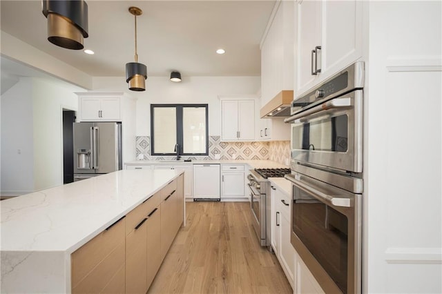 kitchen featuring white cabinetry, high quality appliances, light stone counters, and pendant lighting