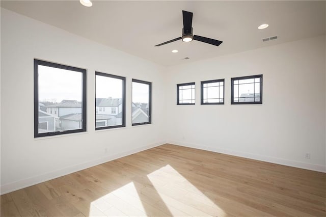 empty room with ceiling fan and light hardwood / wood-style floors