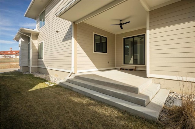 doorway to property featuring ceiling fan and a yard