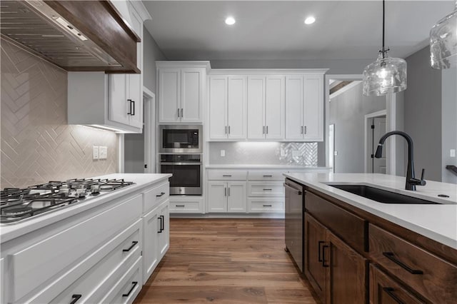 17178 S Heatherwood St, Olathe, KS 66062 - kitchen with appliances with stainless steel finishes, a sink, wall chimney exhaust hood, light countertops, and white cabinets