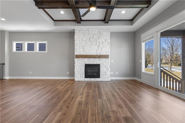 17178 S Heatherwood St, Olathe, KS 66062 - unfurnished living room with coffered ceiling, wood finished floors, baseboards, beamed ceiling, and a stone fireplace