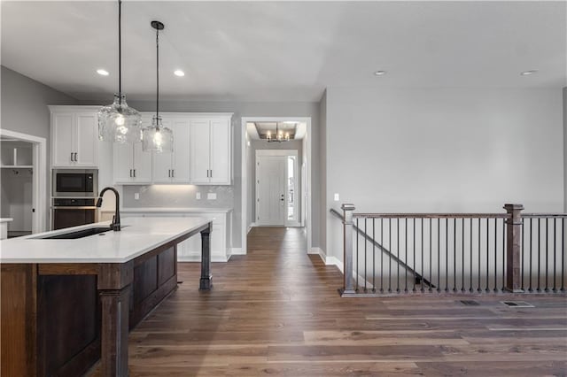 17178 S Heatherwood St, Olathe, KS 66062 - kitchen with dark wood-style floors, stainless steel appliances, a sink, a chandelier, and white cabinetry