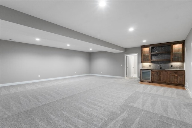 17178 S Heatherwood St, Olathe, KS 66062 - unfurnished living room with beverage cooler, light colored carpet, baseboards, recessed lighting, and bar