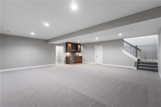 17178 S Heatherwood St, Olathe, KS 66062 - unfurnished living room with baseboards, recessed lighting, stairs, light colored carpet, and bar area