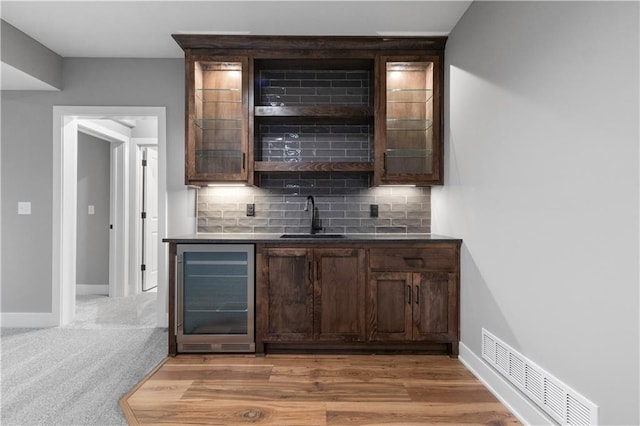 17178 S Heatherwood St, Olathe, KS 66062 - indoor wet bar with wine cooler, tasteful backsplash, baseboards, and light wood-type flooring