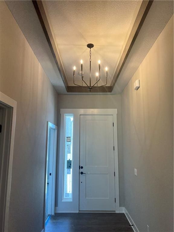 17178 S Heatherwood St, Olathe, KS 66062 - entrance foyer featuring dark wood-style floors, a chandelier, a raised ceiling, and a textured ceiling