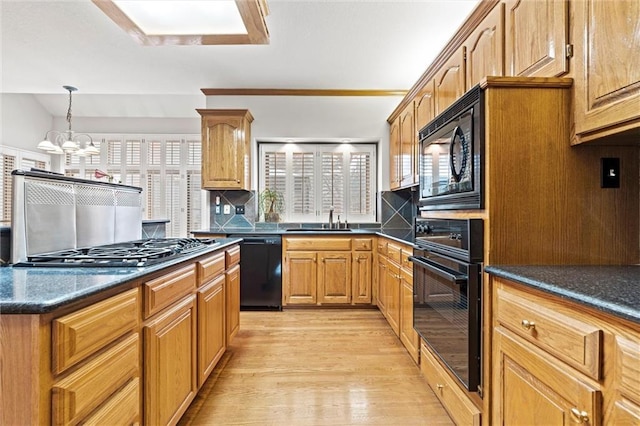 kitchen with light hardwood / wood-style floors, sink, decorative backsplash, and black appliances