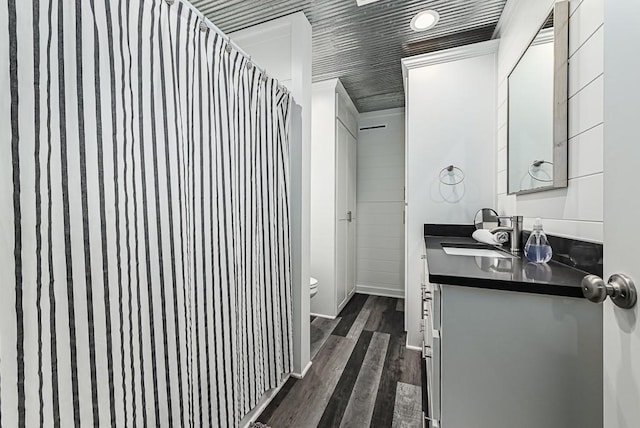 bathroom with vanity, hardwood / wood-style flooring, and toilet