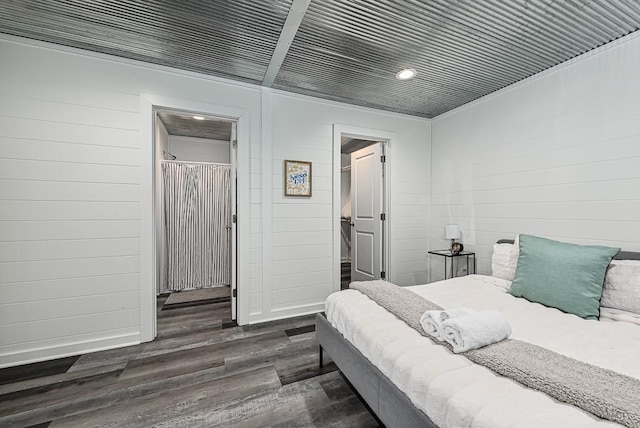 bedroom featuring a walk in closet, dark hardwood / wood-style flooring, and a closet