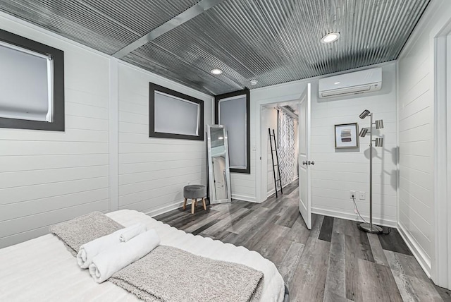 bedroom with dark wood-type flooring and a wall mounted air conditioner