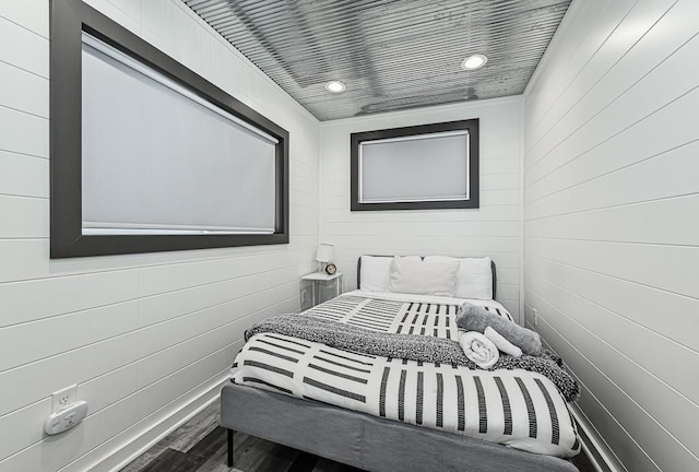 bedroom featuring hardwood / wood-style floors and wood walls