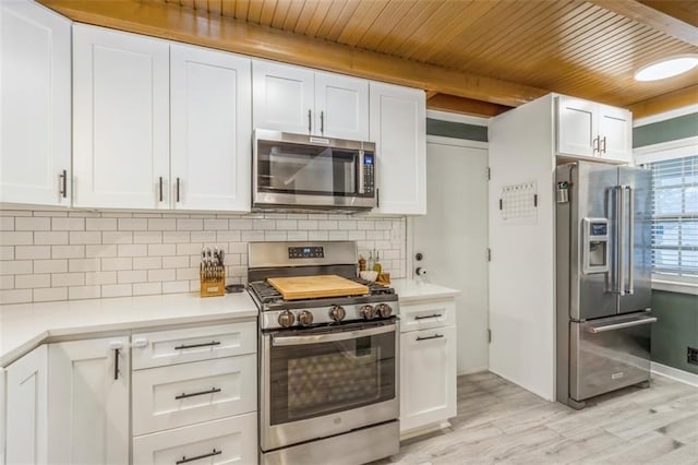 kitchen with light hardwood / wood-style flooring, stainless steel appliances, tasteful backsplash, white cabinets, and wooden ceiling