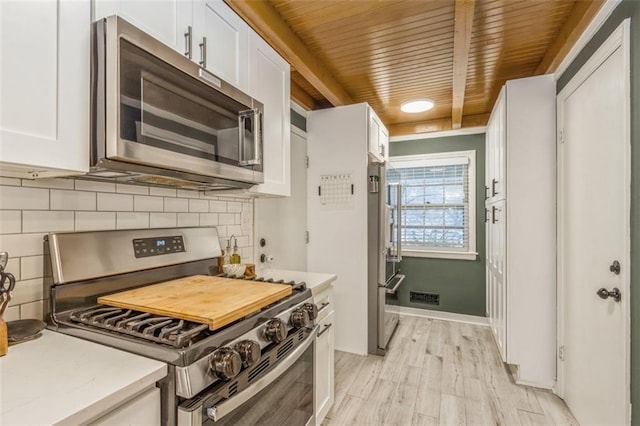 kitchen featuring wood ceiling, light hardwood / wood-style flooring, white cabinets, stainless steel appliances, and backsplash